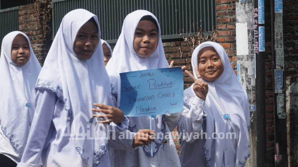 gambar santri putri sedang menunjukkan poster jalan sehat