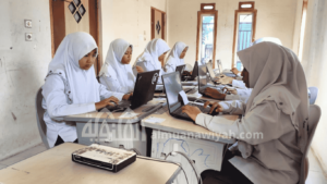 beberapa santri putri sedang mengerjakan ujian berbasis komputer di laboratorium komputer pondok pesantren