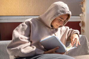 gambar wanita menggunakan hoodie belajar ilustrasi Al-Qur'an membentuk karakter