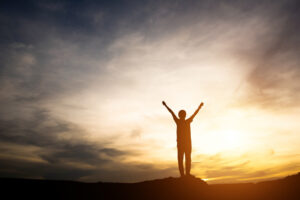 gambar siluet orang mengangka ttangan ilustrasi motivasi sebagai tantangan santri penghafal Al-Qur'an