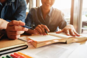 gambar orang menunjuk buku ilustrasi pertimbangan sebelum mendaftar sekolah anak