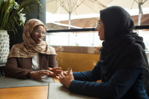 gambar dua wanita berhijab saling berbicara ilustrasi cara menjelaskan pubertas kepada remaja
