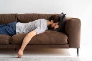gambar pria tidur di sofa larangan bermalas-malasan dalam Islam