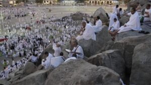 gambar jamaah haji duduk di bebatuan untuk wukuf di Arafah dalam rukun haji
